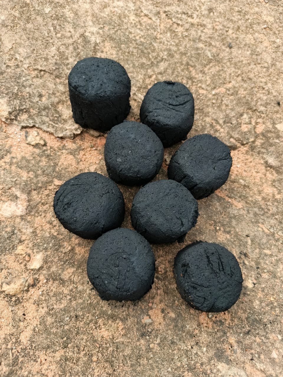 Women producing clean energy briquettes from coconut husks